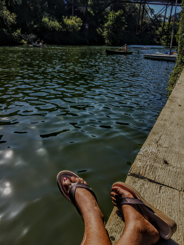 An image of Samirah's feet with hair, resting near water
