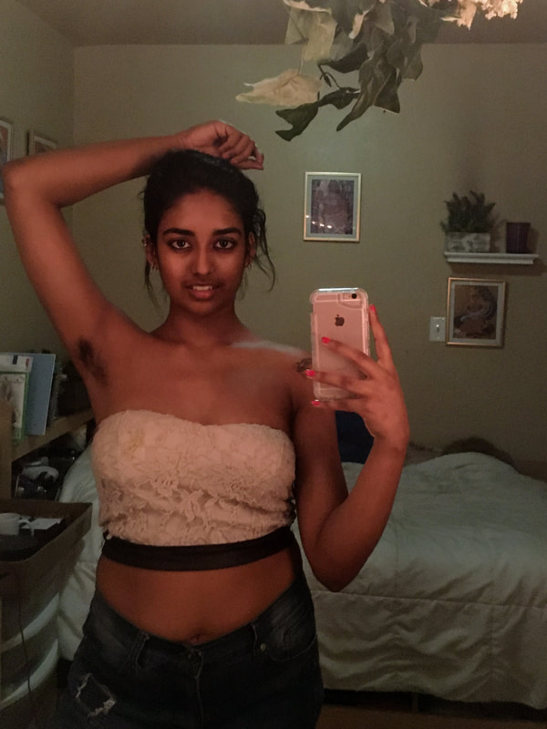 An image of samirah with her arm behind her hair and armpit hair visible